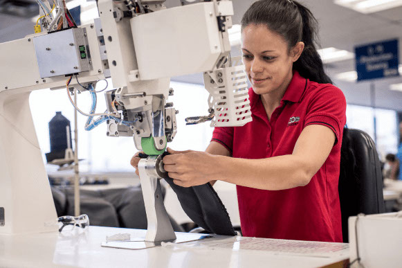 A woman working a machine for a automotive interiors supplier
